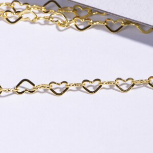 May include: A gold heart-shaped chain necklace. The chain is made of small, delicate hearts linked together.
