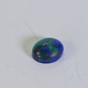 May include: Oval shaped blue and green gemstone cabochon.