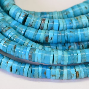 May include: A strand of turquoise beads, each bead is a flat, round disc with a light blue color and a slightly irregular shape.