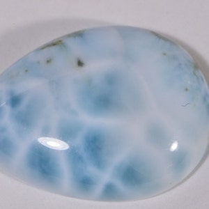 May include: A smooth, light blue and white, oval-shaped, polished gemstone with a cloudy, marbled pattern.