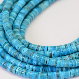 May include: A strand of turquoise beads, each bead is a flat, round disc with a light blue color and a slightly mottled pattern.