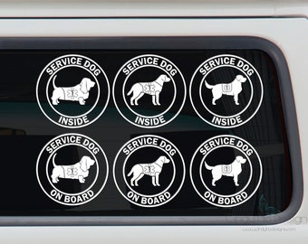 May include: Six white vinyl stickers with black outlines, each featuring a service dog wearing a vest with the words "SERVICE DOG" and either "INSIDE" or "ON BOARD" printed on them.