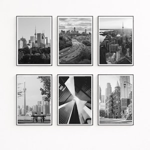 May include: Six framed black and white photographs of Toronto cityscapes. The images showcase the CN Tower, high-rise buildings, highways, and architectural details. The photographs are displayed against a white background.