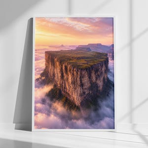 Può includere: Una stampa artistica da parete verticale incorniciata che mostra una fotografia paesaggistica dall'alto di una montagna dalla cima piatta, nota come tepui, che si erge sopra uno strato denso di nuvole bianche durante un'alba dorata.