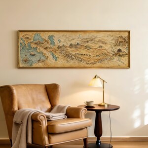 May include: A rectangular wall art piece featuring an antique-style map with a gold frame. The map depicts a landscape with mountains, a desert, a caravan of camels, and coastal areas with a compass rose, rendered in muted earth tones and blue.