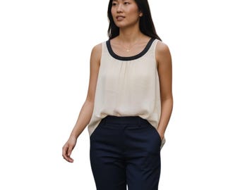 Blusa sin mangas St. John color crema con ribete negro, escote redondo y textura tipo camiseta de tirantes, talla M.