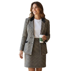 May include: A houndstooth-patterned blazer and skirt set in black and tan. The blazer has a black velvet collar and is paired with a white t-shirt. The person is holding a green and white coffee cup.