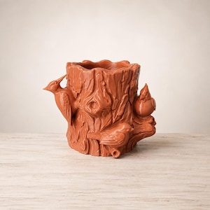 May include: A terracotta-colored ceramic planter shaped like a tree stump with textured bark details. The exterior features three sculpted birds perched on the sides, including a woodpecker on the left and two smaller birds on the right side.