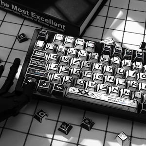 May include: A mechanical keyboard featuring custom black and white keycaps with a comic book style graphic design. The keys display alphanumeric characters, function labels, and text including "HANDLE WITH CARE", "SHIFT", and "PRINT STREAM".
