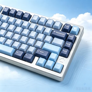 May include: A mechanical keyboard featuring a color scheme of light blue and dark blue keycaps. The keys include standard alphanumeric characters, function keys, and navigation keys. A small heart icon is on the top right key, and a cloud icon is visible.
