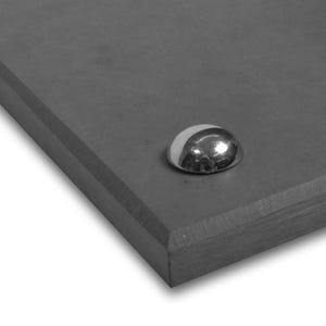 May include: A dark grey, rectangular object with a beveled edge and a shiny, silver, half-sphere shaped metal stud. The stud is positioned near the top right corner of the object. The surface of the object appears to be smooth.