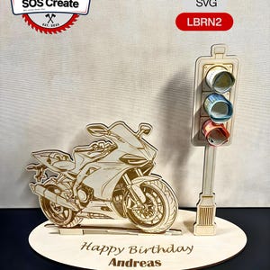 Könnte beinhalten: Lasergeschnittene Holz-Geburtstagsdekoration mit Motorrad und Ampel. Das Motorrad ist detailliert mit Rädern, Sitz und Lenker. Die Ampel hat drei farbige Lichter. Die Basis lautet "Happy Birthday Andreas" und "Digitale Laserdatei".