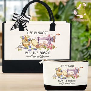 May include: A tote bag and matching zippered pouch set. The white bags feature a black base and handles, with a black and white striped bow on the tote. The design includes a sewing machine, basket of sewing supplies, and the text "LIFE IS SHORT BUY THE FABRIC Samantha."