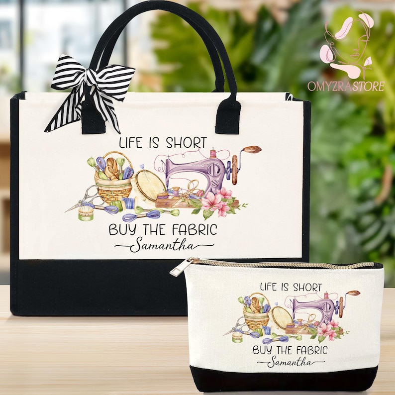 May include: A tote bag and matching zippered pouch set. The white bags feature a black base and handles, with a black and white striped bow on the tote. The design includes a sewing machine, basket of sewing supplies, and the text "LIFE IS SHORT BUY THE FABRIC Samantha."