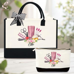 May include: A white tote bag and matching cosmetic bag with black accents. Both bags feature a watercolor design of nail care tools, a pink bottle, and the name "Ellie" in script. A striped bow adorns the tote bag.