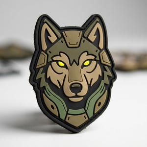 May include: A tactical patch featuring a stylized wolf head design. The patch has a black border with a tan, olive green, and black wolf head. The wolf's eyes are bright yellow. The patch is likely made of rubber or a similar material.