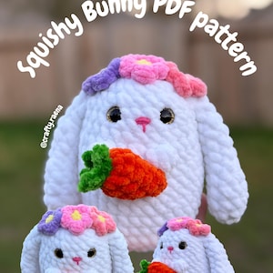May include: White, plush bunny with a carrot and flower crown. The bunny has black eyes and a pink nose. The image includes the text "Squishy Bunny PDF pattern" and the Instagram handle "@crafty.raena".