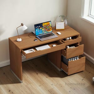 May include: A wooden desk with a laptop, keyboard, and desk lamp. The desk has multiple drawers and a calendar. The laptop screen displays a colorful interface. The desk is made of wood and has a light brown finish.