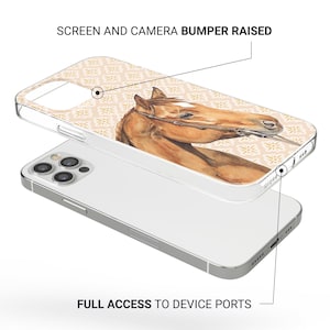 Pode incluir: Capa de telefone transparente com uma pintura em aquarela da cabe&ccedil;a de um cavalo. A capa tem um fundo floral bege. O texto "SCREEN AND CAMERA BUMPER RAISED" e "FULL ACCESS TO DEVICE PORTS" s&atilde;o vis&iacute;veis.