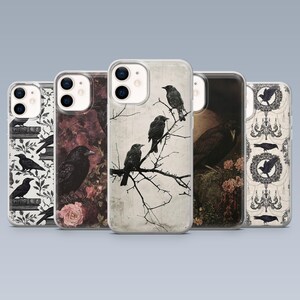May include: A selection of phone cases with raven illustrations. The designs include black ravens on branches, floral arrangements, and gothic motifs. The colour scheme features black, white, grey, and burgundy tones, creating a dark, artistic aesthetic.