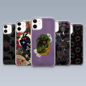 May include: A collection of five phone cases with unique designs. The cases feature various illustrations, including moths, moons, and other spooky elements. The color palette includes black, purple, and red, creating a Halloween or gothic aesthetic.
