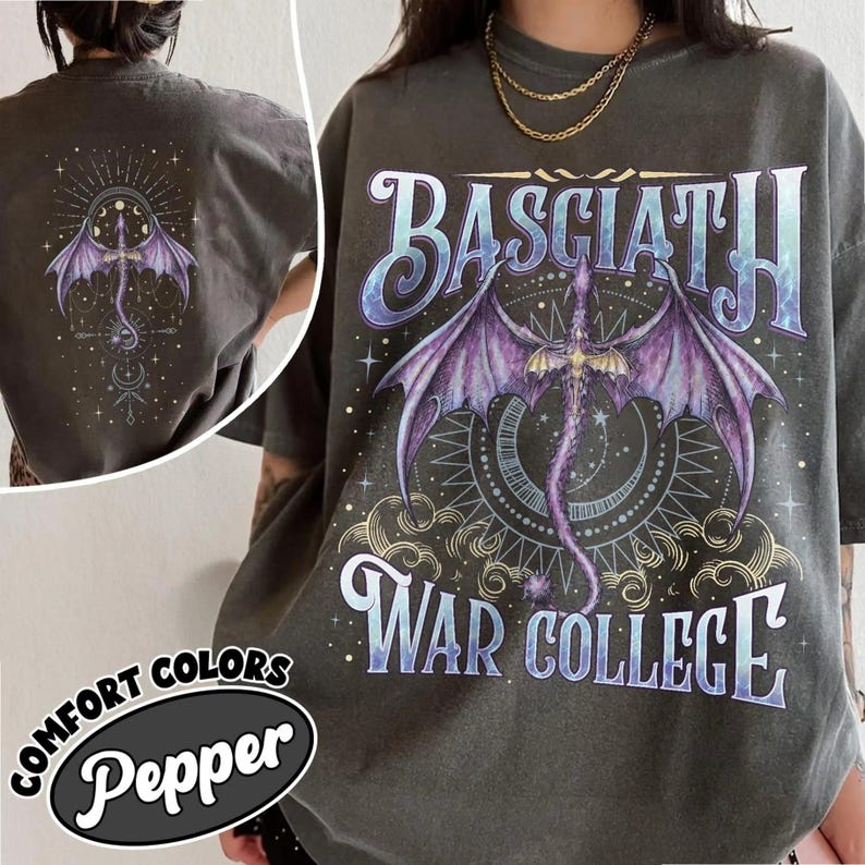 May include: Dark grey t-shirt featuring a purple dragon graphic and the text "BASCIATH WAR COLLEGE". The design includes a dragon with outstretched wings, a crescent moon, and stars. The back of the shirt also features a similar dragon design.