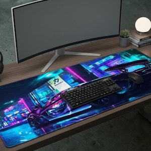 May include: A long, rectangular gaming mouse mat with a vibrant, neon-lit cityscape design featuring a purple sports car. The mat has a black keyboard, mouse, and the text "DARIKI". The mat is on a wooden desk.