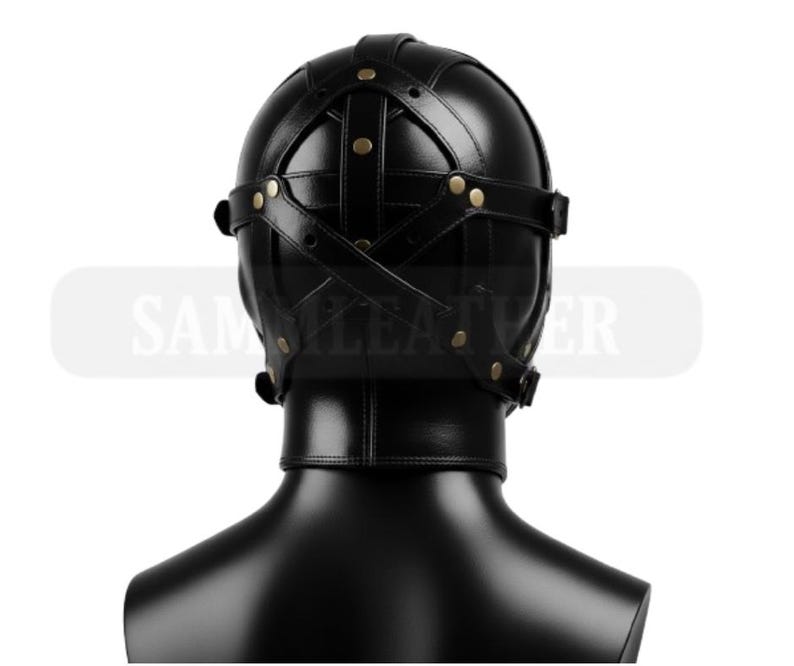 May include: Black leather hood with cross-stitched straps and brass rivets. The hood covers the entire head and neck, with a smooth, glossy finish. The product is displayed on a black mannequin head.