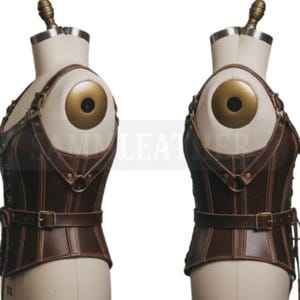 May include: A brown leather corset with a steampunk aesthetic. The corset features a fitted design with straps, buckles, and stitching details. The garment is displayed on a mannequin with a gold-colored shoulder detail.