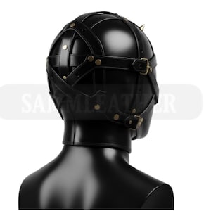 May include: Black leather hood with straps and buckles. The hood features a rounded top with small, gold-colored spikes. The design includes multiple straps that cross over the head and are secured with brass-colored buckles. The product is designed for role-playing.