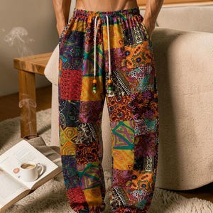 May include: Loose-fitting trousers featuring a vibrant patchwork design with various colourful paisley, floral, and geometric patterns. The trousers have an elastic waistband with a white drawstring finished with wooden beads and elasticated cuffs.