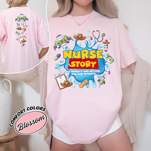 May include: Light pink t-shirt with a colorful graphic that says "Nurse Story" with medical-themed illustrations. The back of the shirt has similar graphics. The shirt is a comfort colors brand.