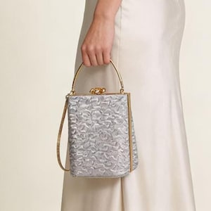 May include: A rustic wooden sign with the text "Welcome" in a handwritten style. The sign is painted white with a distressed finish, and features a decorative floral element in the corner. The background is a blurred image of a wooden surface.