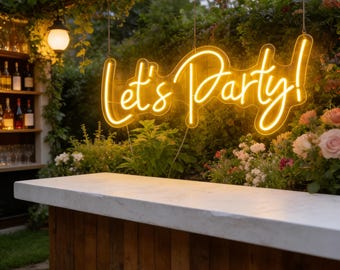 May include: A neon sign that reads "Let's Party!" hangs above a wooden bar with a white countertop. The sign is illuminated in a warm yellow color. The background features lush greenery, flowers, and a small bar with bottles.