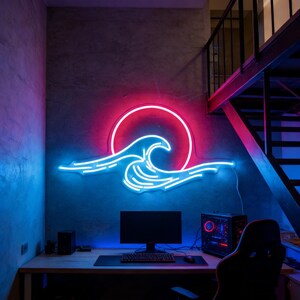 Peut inclure: Enseigne au néon représentant un motif de vague et de soleil en rouge et bleu. L'enseigne est fixée sur un mur gris au-dessus d'un bureau avec une configuration informatique. La pièce a une esthétique moderne et minimaliste.