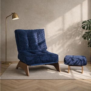 May include: A navy blue corduroy armchair and matching ottoman with wooden legs. The chair has a tufted back and seat. A gold floor lamp is in the background, and the furniture sits on a neutral-colored rug.