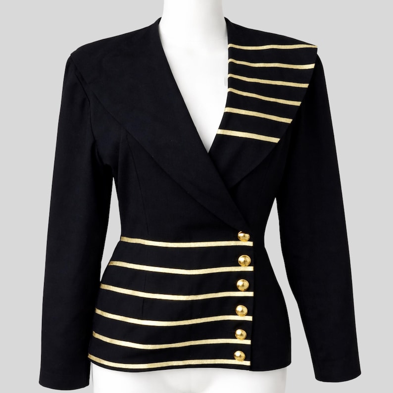 Black women’s asymmetrical blazer with gold stripes and buttons, featuring a tailored fit and modern military-inspired design on a mannequin.