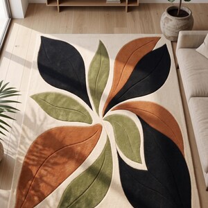 Handcrafted botanical leaf Teppich featuring large deep black and muted olive green organic flowing shapes on a soft cream base.
