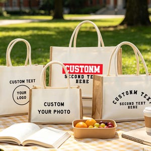 May include: Four rectangular tote bags made of cream-colored fabric with natural jute side panels and handles. Each bag features different black or red printed text and graphic designs, including the phrases CUSTOM TEXT, CUSTOM YOUR PHOTO, and SECOND TEXT HERE.