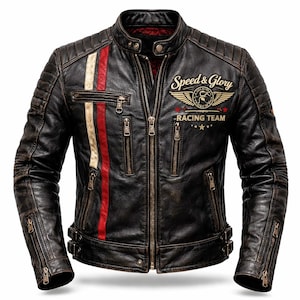 Op de afbeelding: Een zwarte leren jas met een distressed afwerking, met een rode en crème streep aan de linkerkant. De jas heeft meerdere ritszakken en de tekst "Speed & Glory Racing Team" met een embleem.
