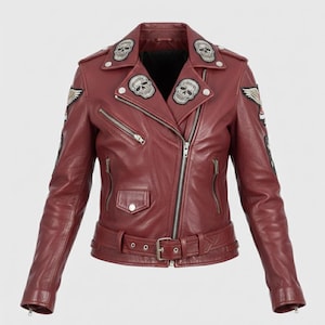 May include: Burgundy leather jacket with skull and wing patches. Features a notched collar, multiple zippered pockets, and a belted waist. The jacket has silver zippers and hardware. A stylish biker-inspired design.
