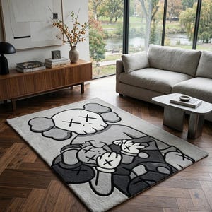 Pu&ograve; includere: Un tappeto rettangolare con un'illustrazione grafica di due personaggi dei cartoni animati con occhi a forma di X. Il design utilizza una tavolozza monocromatica di grigio chiaro, grigio scuro e bianco, con marcati contorni neri.