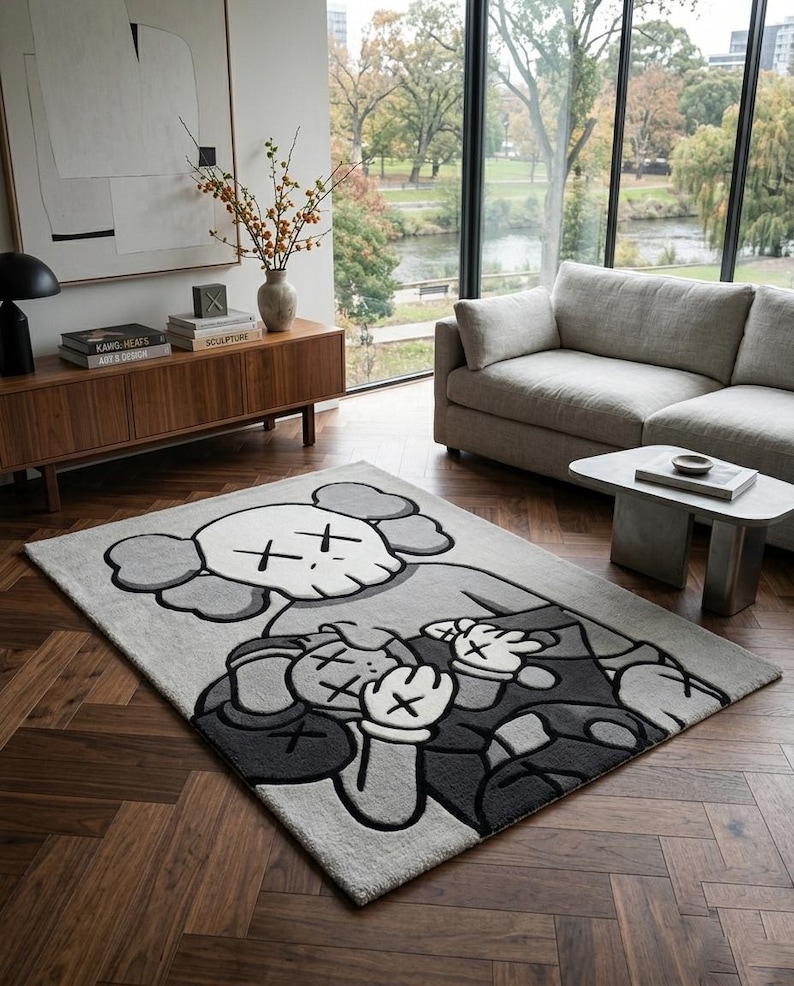 Pu&ograve; includere: Un tappeto rettangolare con un'illustrazione grafica di due personaggi dei cartoni animati con occhi a forma di X. Il design utilizza una tavolozza monocromatica di grigio chiaro, grigio scuro e bianco, con marcati contorni neri.