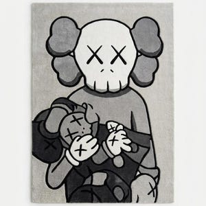 Pu&ograve; includere: Un tappeto rettangolare con un'illustrazione grafica monocromatica in grigio, nero e bianco di un personaggio dei cartoni animati con occhi a forma di X che tiene in braccio una figura pi&ugrave; piccola. Il design usa contorni neri e toni di grigio.