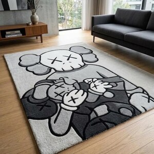 Pu&ograve; includere: Un tappeto rettangolare caratterizzato da un grande motivo grafico trapuntato nei toni del grigio, nero e bianco. Il disegno raffigura due personaggi dei cartoni animati stilizzati con occhi a forma di X, sovrapposti, in uno stile dai contorni marcati.