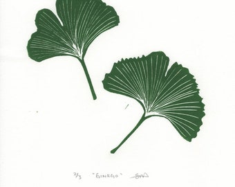 May include: A green print of two ginkgo leaves on white paper. The print is numbered 2/3 and titled "Ginkgo".