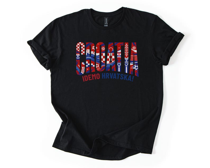 Puede incluir: Camiseta negra con la palabra "CROATIA" en rojo, blanco y azul, con varios dise&ntilde;os inspirados en la bandera croata dentro de las letras. Debajo est&aacute; el texto "IDEMO HRVATSKA!"