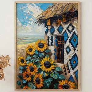 May include: Oil painting of a rustic building with a thatched roof and blue and white geometric patterns. Sunflowers in full bloom are in the foreground. The artwork is framed in a light wood frame.