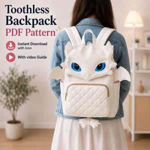May include: Cream-coloured backpack with a dragon design, featuring blue eyes and wings. The backpack has a quilted front pocket and a small dragon tail detail. The text "Toothless Backpack PDF Pattern" is visible.