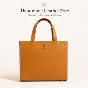 May include: A tan leather tote bag with short handles. The bag has a rectangular shape with a small square metal emblem on the front. The text "Handmade Leather Tote" is above the bag, with the words "Minimal, Premium, Durable" below.
